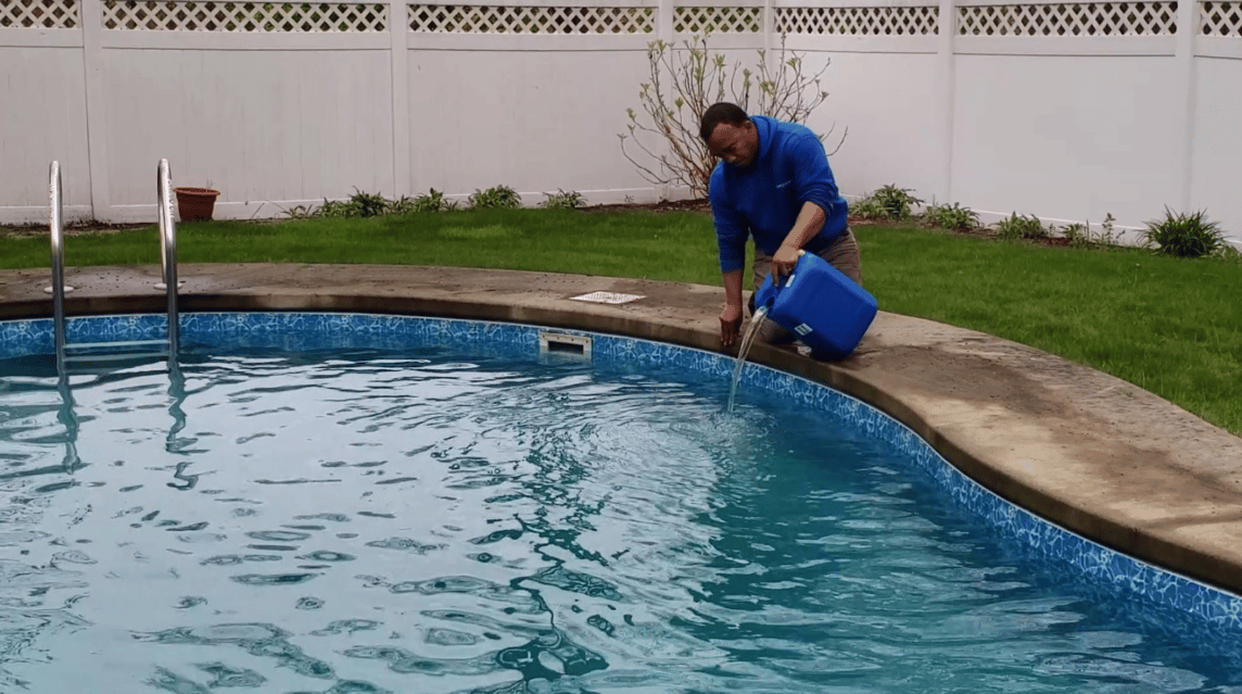 Professional pouring chlorine into pool