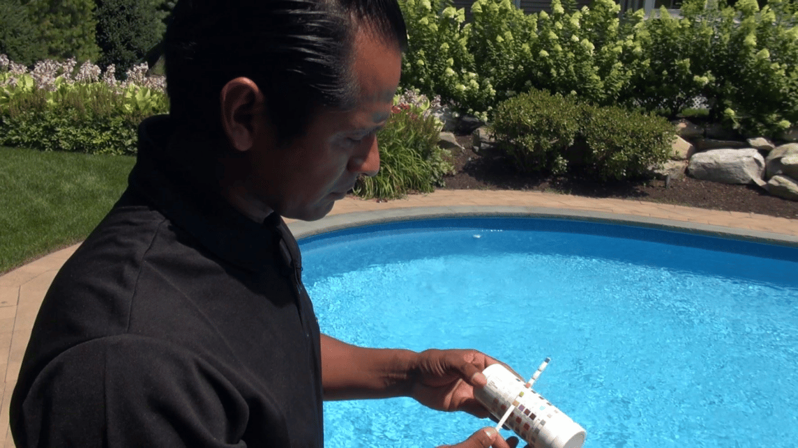 Man holding pool water test kit