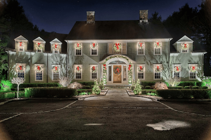 A mansion with several Christmas lights and decors