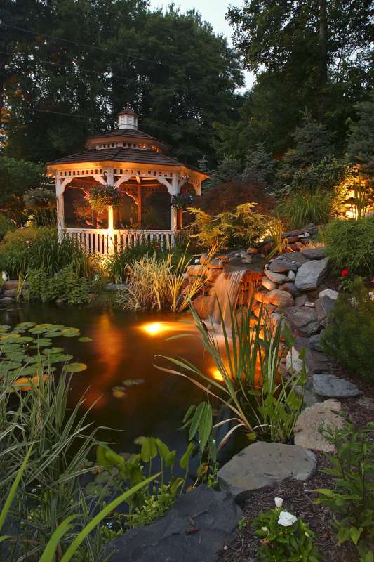 Residential outdoor lighting illuminating pond and gazebo
