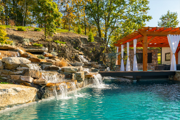 Idyllic backyard pool adorned with stunning stonework and enchanting waterfalls, creating a serene and captivating retreat.
