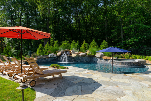 Invigorating outdoor gunite pool featuring captivating water features, blending serenity and excitement in a harmonious oasis.