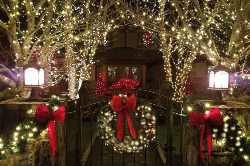 An enchanting Christmas wonderland awaits at this house, as seen from the gate that was done by our professional holiday decorating services