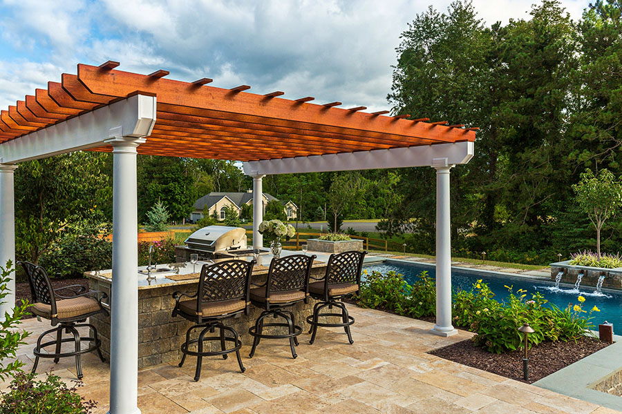 Elegant pergola with grill and table beside a luxurious pool area
