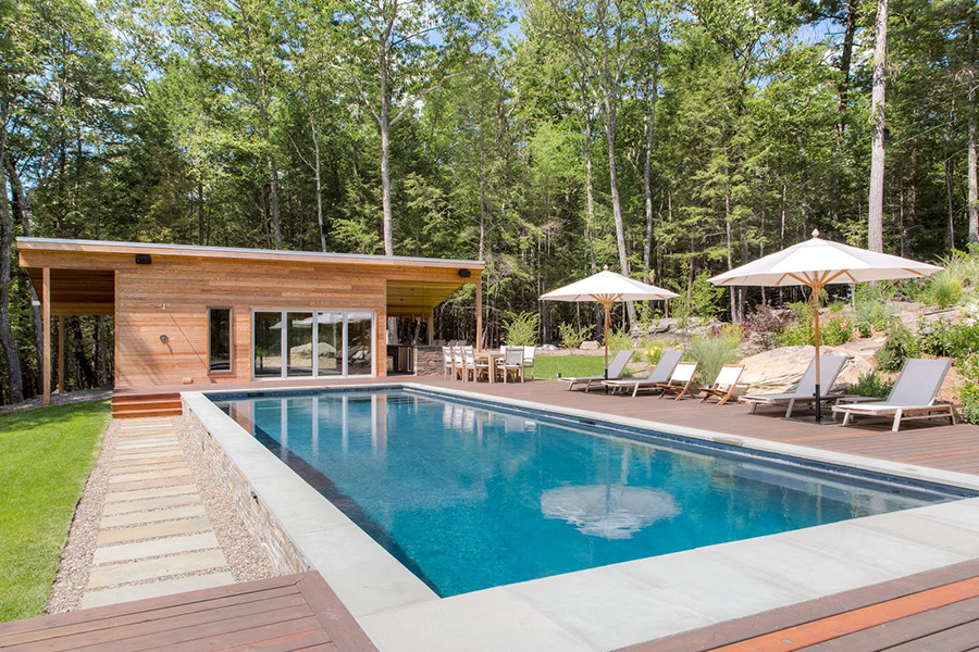 Modern backyard with a sleek pool installed by fiberglass pool installers, surrounded by lush greenery and decking Modern backyard with a sleek pool installed by fiberglass pool installers, surrounded by lush greenery and decking